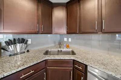 a kitchen with a sink and wooden cabinets at Comfortable 2BR Condo near City Center in Cincinnati