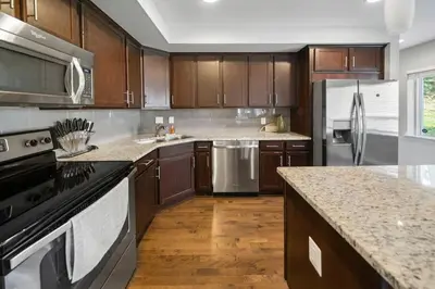 a kitchen with stainless steel appliances and wooden cabinets at Comfortable 2BR Condo near City Center in Cincinnati