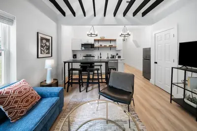 a living room with a blue couch and a kitchen at Spacious and Modern 3BR near Downtown and Walnut Hills in Cincinnati