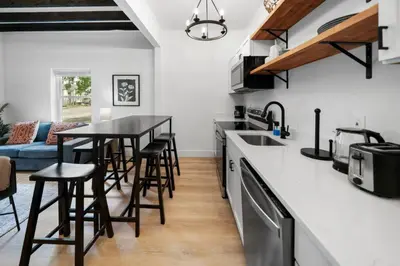 a kitchen with a counter top and a table with stools at Spacious and Modern 3BR near Downtown and Walnut Hills in Cincinnati