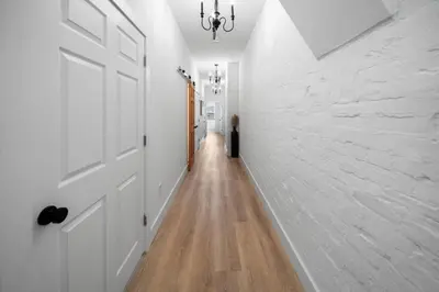 a hallway with white walls and a door and a wooden floor at Spacious and Modern 3BR near Downtown and Walnut Hills in Cincinnati