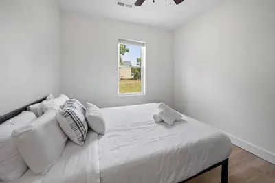 a white bedroom with a bed with a window at Spacious and Modern 3BR near Downtown and Walnut Hills in Cincinnati