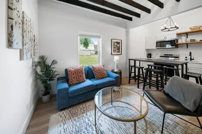 a living room with a blue couch and a table at Spacious and Modern 3BR near Downtown and Walnut Hills in Cincinnati