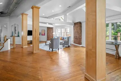 a living room with wooden floors and a dining room at Hyde Park Penthouse with Private Patio in Cincinnati