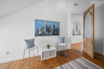 a living room with two chairs and a mirror at Hyde Park Penthouse with Private Patio in Cincinnati