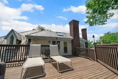two chairs on a wooden deck with a house at Hyde Park Penthouse with Private Patio in Cincinnati