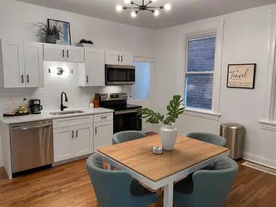 a kitchen with a wooden table and blue chairs at Explore Downtown from Adorable Mount Adams in Cincinnati
