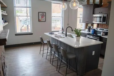 a kitchen with a large island with bar stools at Gorgeous Condo in the Heart of OTR Free Parking in Cincinnati