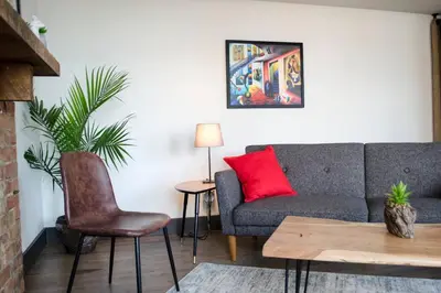 a living room with a couch and a red pillow at Gorgeous Condo in the Heart of OTR Free Parking in Cincinnati