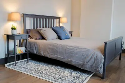 a bedroom with a large bed with a nightstand and a bed sidx sidx sidx at Gorgeous Condo in the Heart of OTR Free Parking in Cincinnati