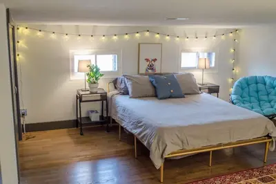a bedroom with a bed and two blue chairs at Gorgeous Condo in the Heart of OTR Free Parking in Cincinnati