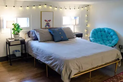 a bedroom with a bed and a blue chair at Gorgeous Condo in the Heart of OTR Free Parking in Cincinnati