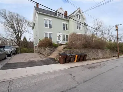 a white house with a bunch of trash cans on a street at Cozy 1BR Near Zoo, UC, OTR, Downtown in Cincinnati
