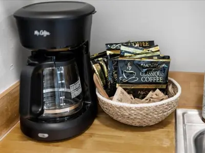 a coffee maker on a counter next to a basket of chips at Cozy 1BR Near Zoo, UC, OTR, Downtown in Cincinnati