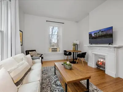 a living room with a white couch and a fireplace at Cozy 1BR Near Zoo, UC, OTR, Downtown in Cincinnati
