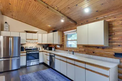 a kitchen with white cabinets and a wooden ceiling at Cozy Brookville Home with Fire Pit and Deck! in Brookville