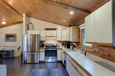 a kitchen with white cabinets and a wooden ceiling at Cozy Brookville Home with Fire Pit and Deck! in Brookville