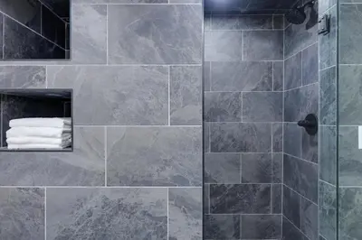a bathroom with a shower with gray tiles at Cozy Brookville Home with Fire Pit and Deck! in Brookville