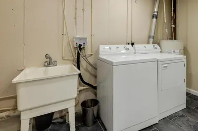 a kitchen with a sink and a washing machine at Cozy Brookville Home with Fire Pit and Deck! in Brookville