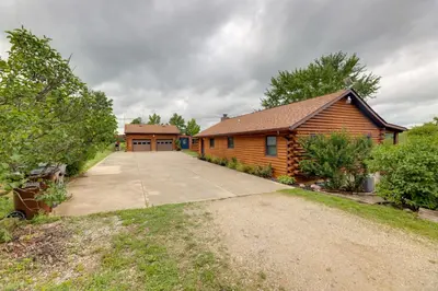 a log cabin with a driveway in front of a house at Cozy Brookville Home with Fire Pit and Deck! in Brookville
