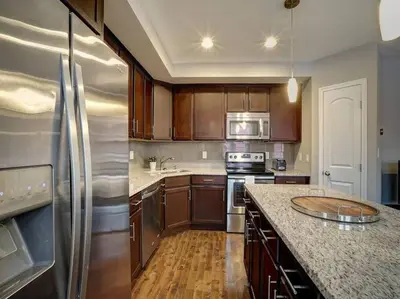 a kitchen with wooden cabinets and stainless steel appliances at Bright 2BR near downtown in Cincinnati