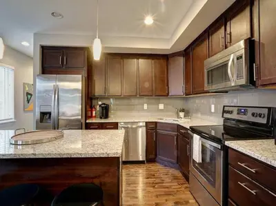 a kitchen with wooden cabinets and stainless steel appliances at Bright 2BR near downtown in Cincinnati