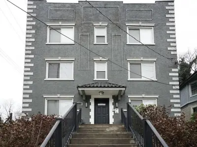 a gray brick house with stairs leading to the door at Bright 2BR near downtown in Cincinnati