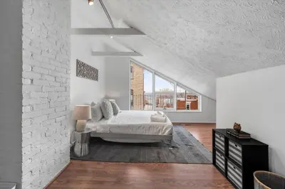 a bedroom with a bed and a brick wall at Stylish Mt Adams 1BR in great location in Cincinnati
