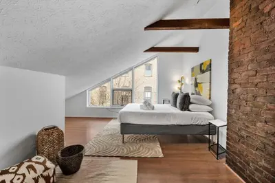 a bedroom with a bed and a brick wall at Charming Mt Adams 1BR in Prime Location in Cincinnati
