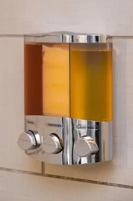 a towel dispenser on a wall in a bathroom at Two Comfy Condos Near City Center OTR UC Zoo in Cincinnati