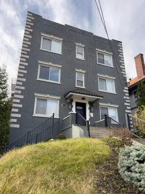a gray house with white windows on a hill at Two Comfy Condos Near City Center OTR UC Zoo in Cincinnati