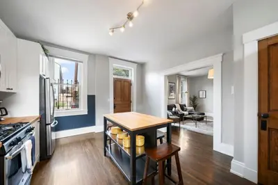 a kitchen with a table and a stove top oven at Walkable 2BR near Findlay Market Downtown UC in Cincinnati