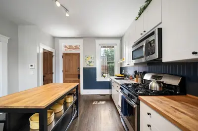 a kitchen with a stove and a wooden counter top at Walkable 2BR near Findlay Market Downtown UC in Cincinnati