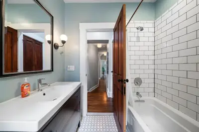 a bathroom with a tub and a sink and a mirror at Walkable 2BR near Findlay Market Downtown UC in Cincinnati