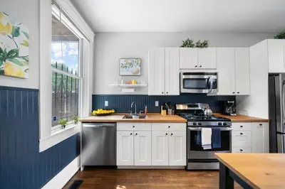 a kitchen with white cabinets and a sink at Walkable 2BR near Findlay Market Downtown UC in Cincinnati