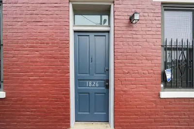 a blue door on a red brick building with a window at Walkable 2BR near Findlay Market Downtown UC in Cincinnati