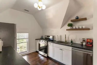 a kitchen with white cabinets and a stove top oven at Spacious Studio Central Locale in Cincinnati