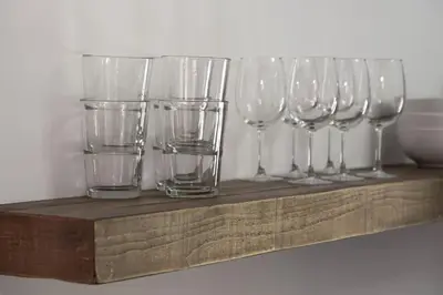 a row of wine glasses sitting on a wooden shelf at Spacious Studio Central Locale in Cincinnati