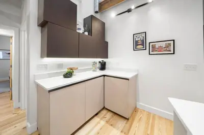 a kitchen with white walls and a white counter top at Huge Retrea w Rooftop Deck Stay At Farmers Market in Cincinnati
