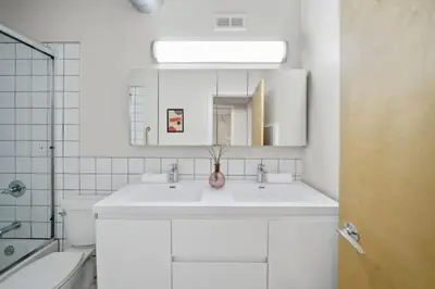 a white bathroom with two sinks and a mirror at Huge Retrea w Rooftop Deck Stay At Farmers Market in Cincinnati