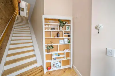 a staircase in a room with a book shelf at Huge Retrea w Rooftop Deck Stay At Farmers Market in Cincinnati