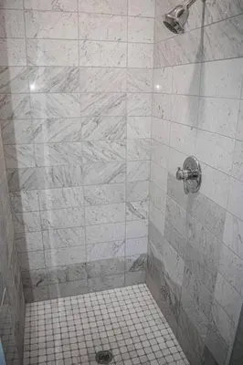 a bathroom with a shower with a tiled floor at Great Parkside Microapartment Location AND Price in Cincinnati