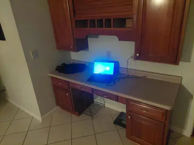 a laptop computer sitting on a desk in a kitchen at 4BR Home - Pets Allowed by ARK Experience in Williamstown