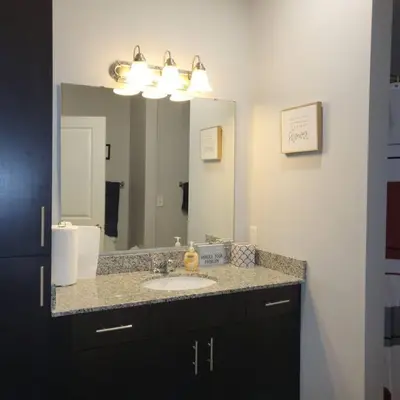 a bathroom with a sink and a large mirror at Stylish and Spacious, close to the Hospital. in Fort Wayne