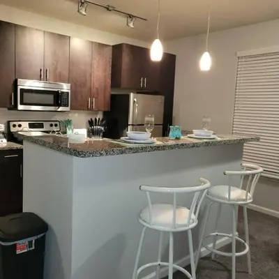 a kitchen with a counter and two bar stools at Stylish and Spacious, close to the Hospital. in Fort Wayne