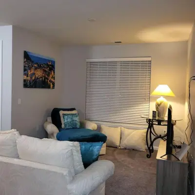 a living room with a white couch and a chair at Stylish and Spacious, close to the Hospital. in Fort Wayne