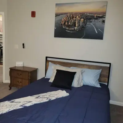 a bedroom with a blue bed with a picture on the wall at Stylish and Spacious, close to the Hospital. in Fort Wayne