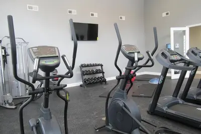 a gym with three exercise bikes and a flat screen tv at Stylish and Spacious, close to the Hospital. in Fort Wayne