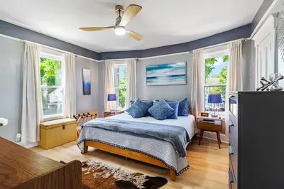 a bedroom with a bed with blue pillows and windows at Modern Oakley Retreat - King Bed - Free Parking - Centrally Located in Cincinnati