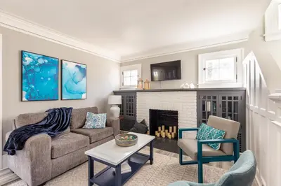 a living room with a couch and a fireplace at The 1920’s Dutch Colonial - Highland Square in Akron
